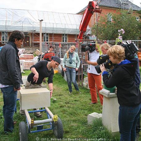 Die nächste Szene wird vorbereitet: Jenny Lux, Steinmetzmeisterin aus Erfurt legt eine Schablone an den etwa 100 Kilogramm schweren Kalksandsteinblock an. Später wird Jo Hiller sein Glück am Ausmodellieren probieren. © 2012 Betrieb für Bau und Liegenschaften Mecklenburg-Vorpommern