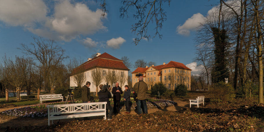 ten Rabatte - Der Abspann der Sendung Land und Leute wird gedreht: Jana Giesa vom BBL M-V und Peter J. Harke vom NDR im Vordergrund, das Schloss (rechts) und Kavalierhaus (links) im Hintergrund. © 2014 Betrieb für Bau und Liegenschaften Mecklenburg-Vorpommern
