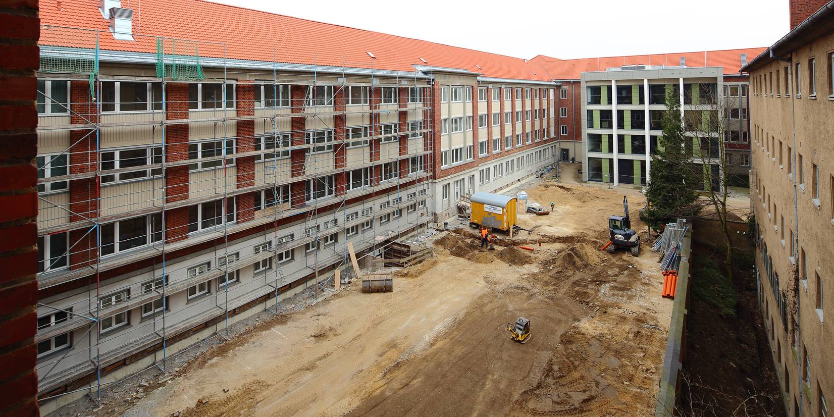 Blick aus einem unsanierten Büro im 3. Bauabschnitt auf den 2. Bauabschnitt (links), den 1. Bauabschnitt (gegenüber) und die Dokumentations- und Gedenkstätte (rechts). © 2015 Betrieb für Bau und Liegenschaften Mecklenburg-Vorpommern