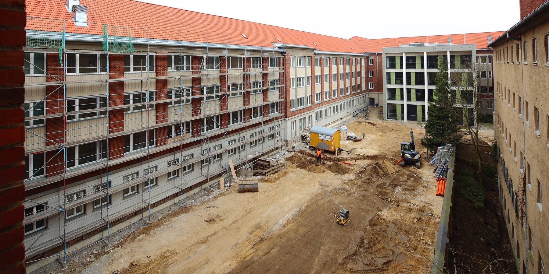 Blick aus einem unsanierten Büro im 3. Bauabschnitt auf den 2. Bauabschnitt (links), den 1. Bauabschnitt (gegenüber) und die Dokumentations- und Gedenkstätte (rechts). © 2015 Betrieb für Bau und Liegenschaften Mecklenburg-Vorpommern