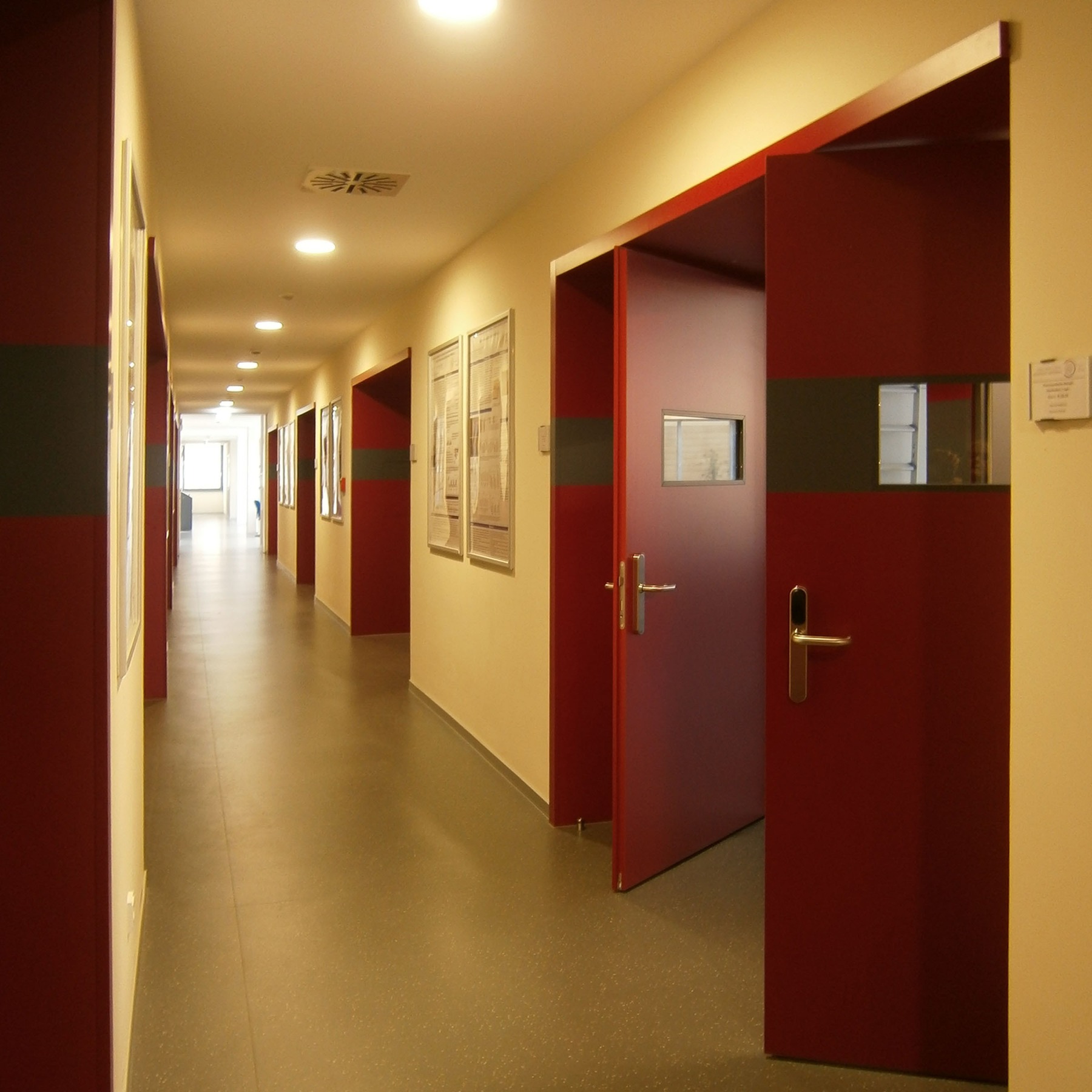 Flur im 1. Obergeschoss von Bauteil D - die rote Farbgebung der Türen ist in beiden Bauabschnitten prägendes Gestaltungsmerkmal © 2015 Betrieb für Bau und Liegenschaften Mecklenburg-Vorpommern