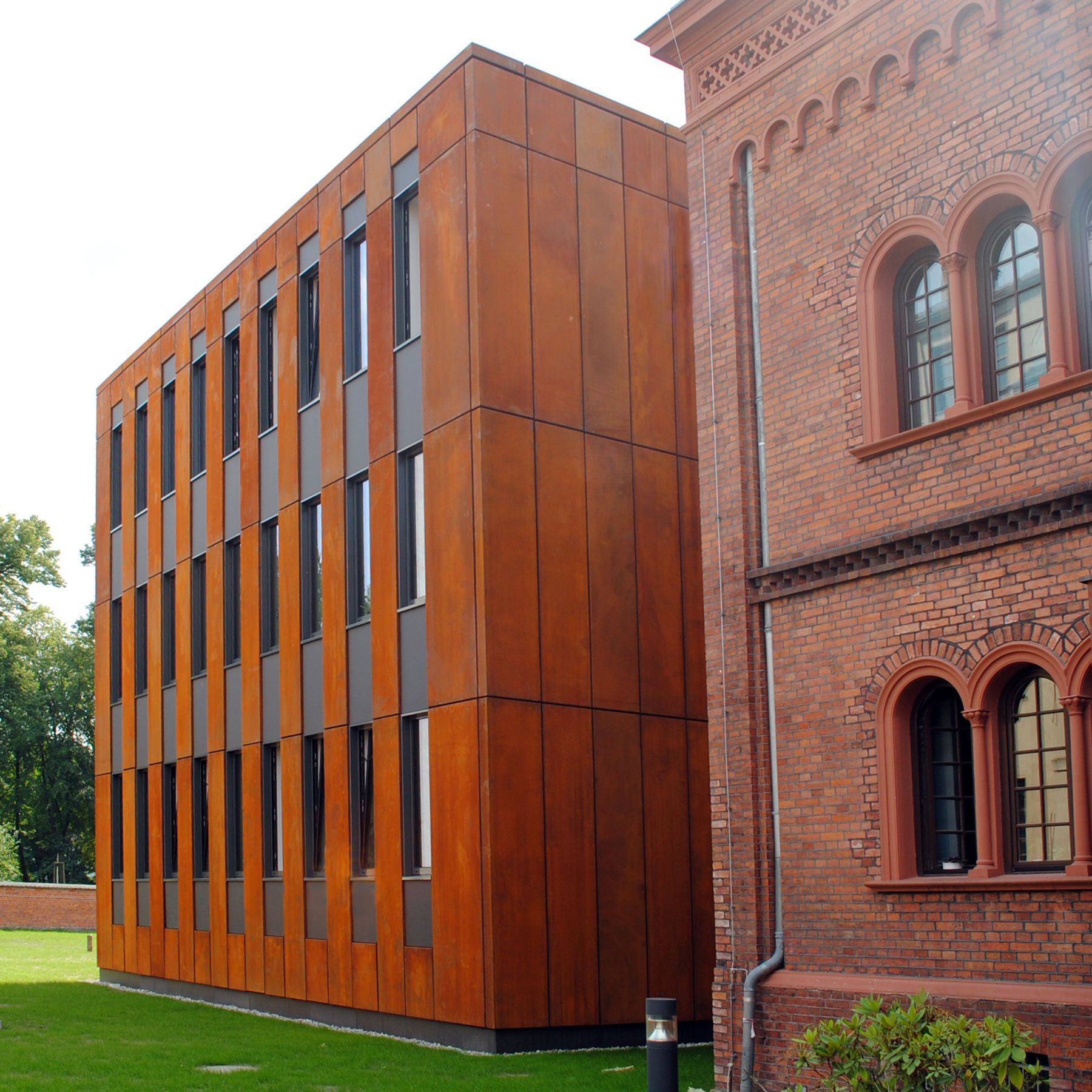 Rückansicht des Gebäudes, durch die Weiterführung der tiefroten Fassadenstruktur als Metallfassade wird die Ensemblewirkung erreicht. © 2015 Betrieb für Bau und Liegenschaften Mecklenburg-Vorpommern