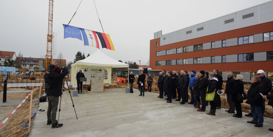 Uwe Sander, Leiter des BBL M-V Geschäftsbereich Hochschul- und Klinikbau begrüßt die Gäste der Grundsteinlegung auf dem Baufeld. © 2016 Betrieb für Bau und Liegenschaften Mecklenburg-Vorpommern