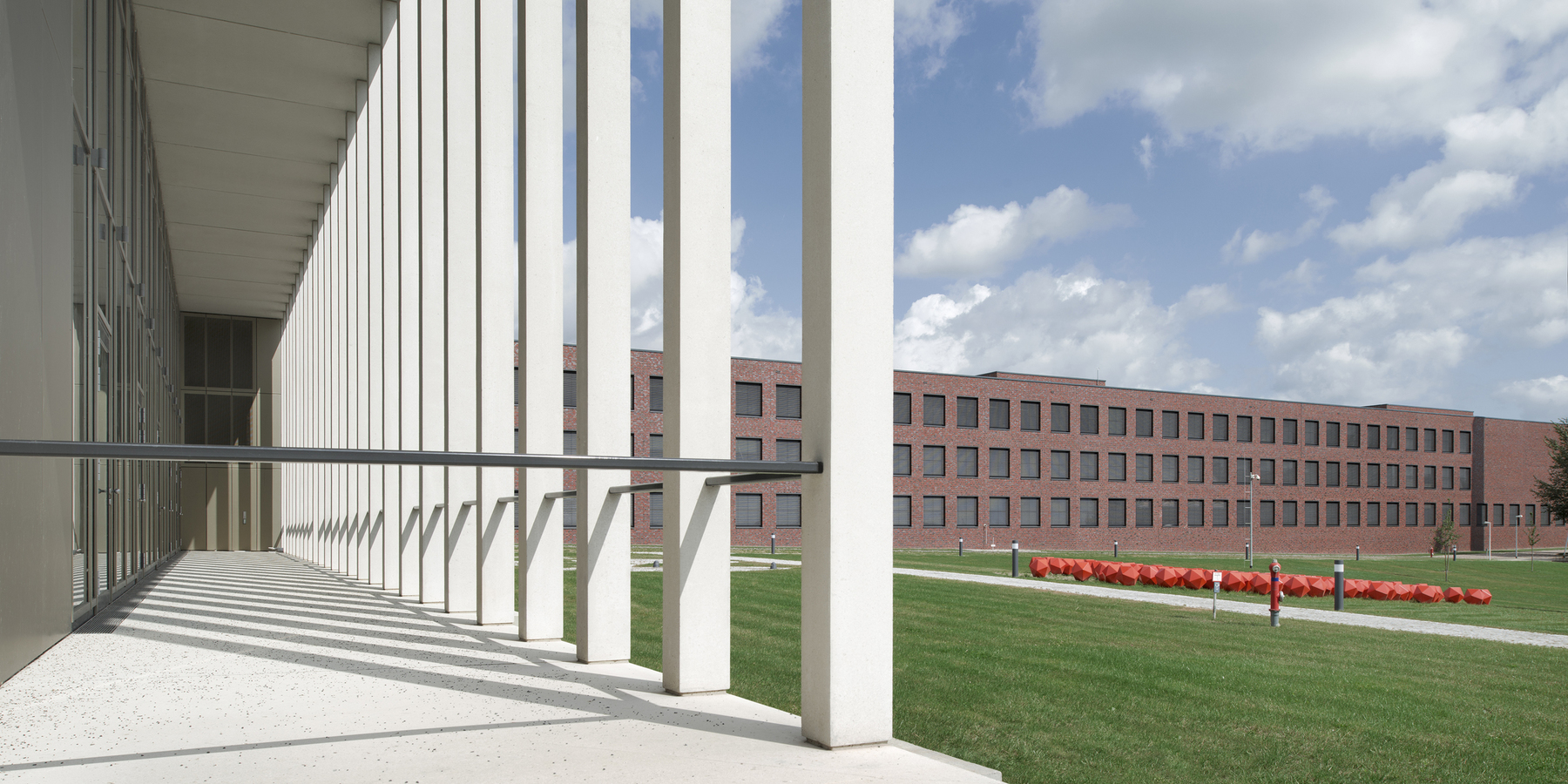 Blick vom Karree (Büro/Konferenz/Kantine-Komplex) auf das Laborgebäude und auf die Rasenfläche mit der Kunst am Bau. © Marion Schmieding/ Alexander Obst