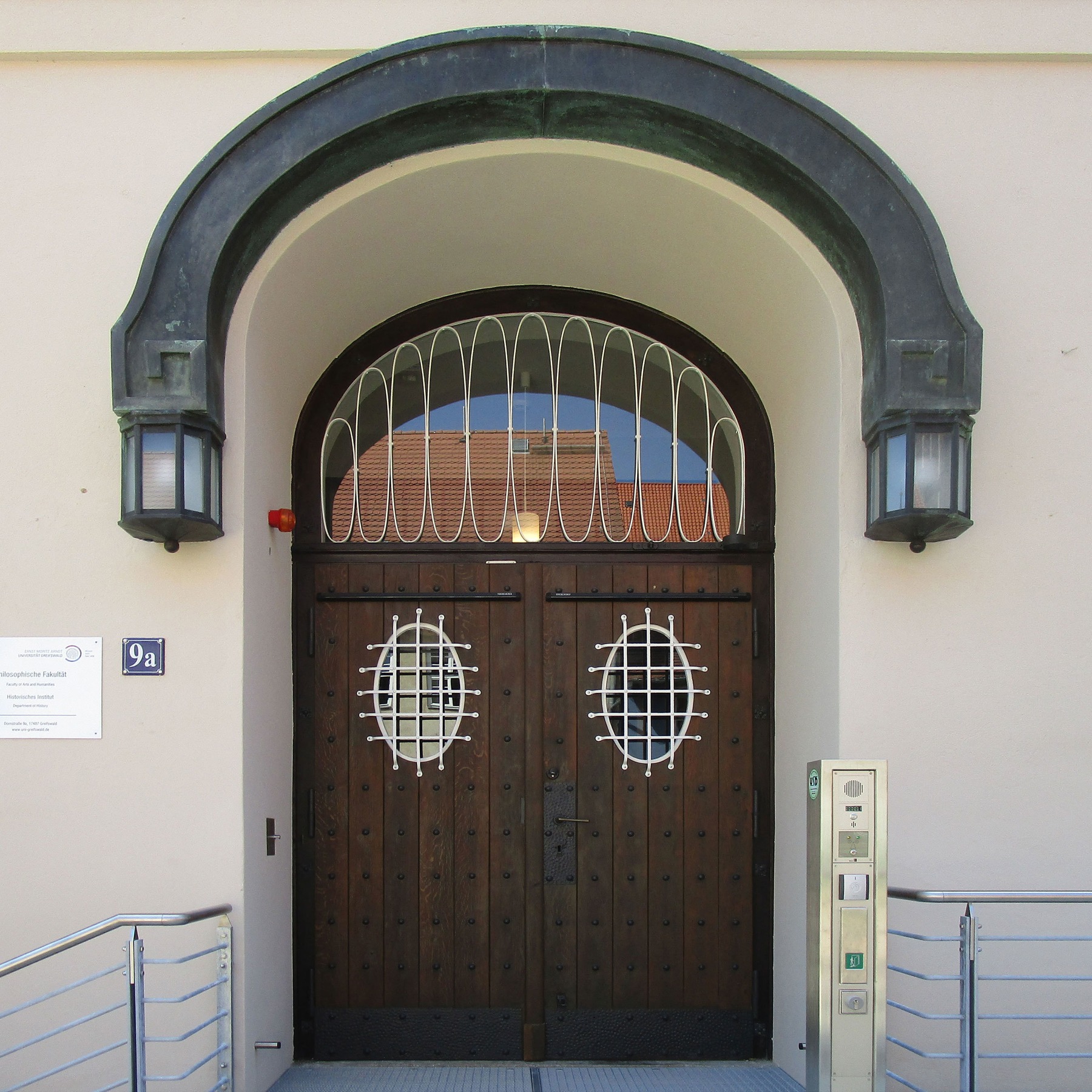 Eingangsbereich mit sanierter historischer Holztür und bogenförmigem Schmuckelement inkl. Außenleuchten aus Kupfer © 2017 Betrieb für Bau und Liegenschaften Mecklenburg-Vorpommern