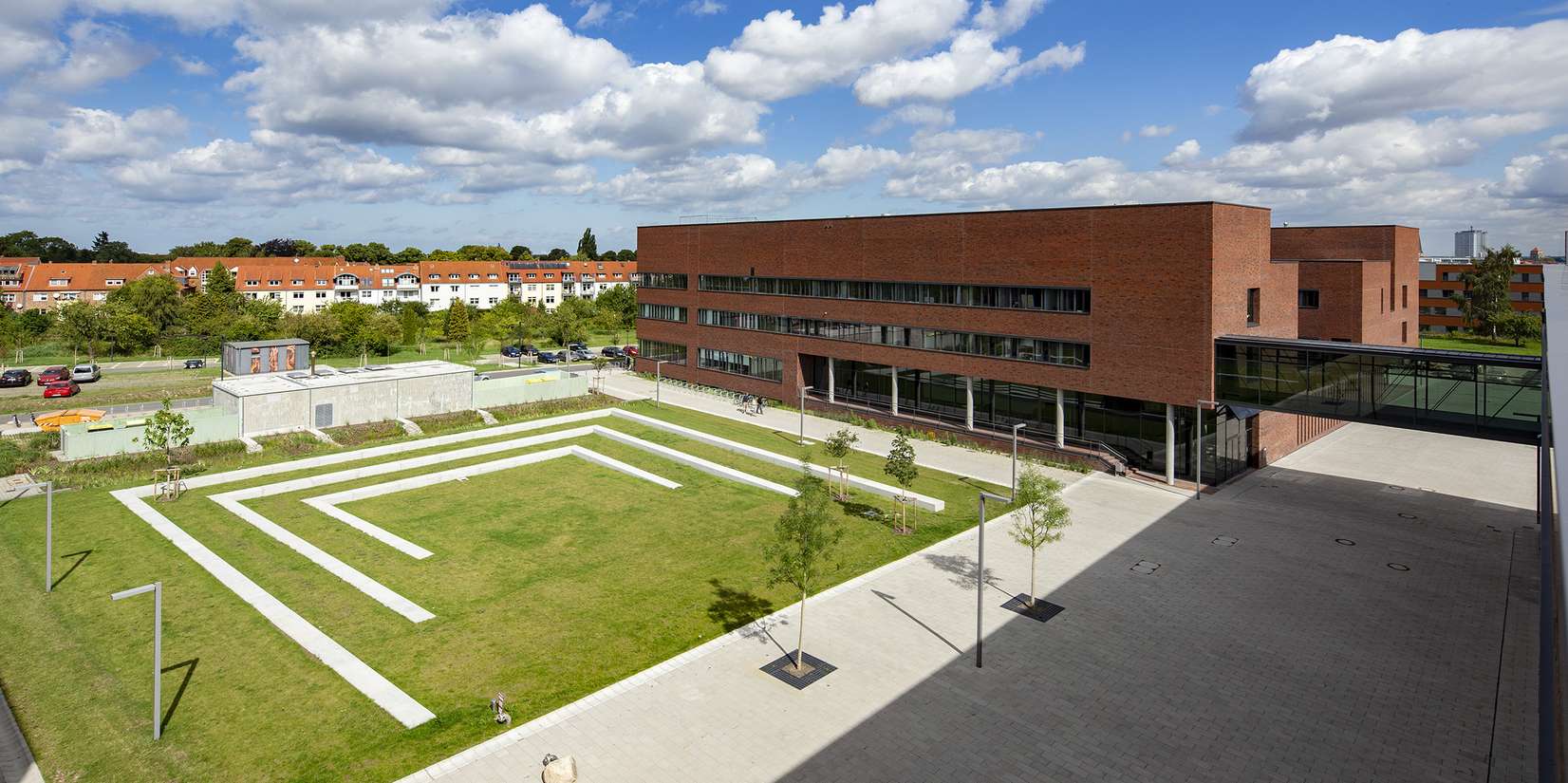 Blick vom Forschungsgebäude der Physik auf das Hörsaalgebäude mit dem dahinter liegenden Department Leben, Licht und Materie sowie der Freifläche zwischen Hörsaalgebäude und Institut für Informatik und Rechenzentrum mit audiovisuellem Medienzentrum. © 2015 Betrieb für Bau und Liegenschaften Mecklenburg-Vorpommern