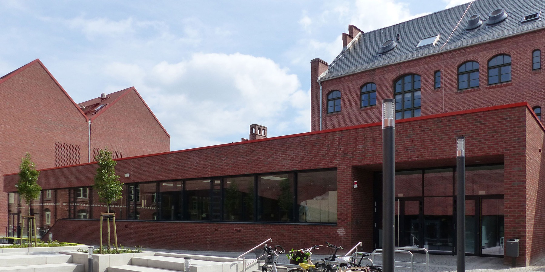 Der Neubau der Cafeteria passt sich in seiner äußeren Gestaltung an die umgebende Campusbebauung an. © 2018 Betrieb für Bau und Liegenschaften Mecklenburg-Vorpommern