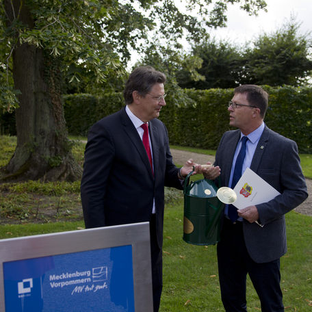 Zum Gießen! Finanzminister Reinhard Meyer übergibt mit der Gießkanne die Verantwortung für die Pflege des hergerichteten Schlossgartens an Neustrelitz  Bürgermeister Andreas Grund. © 2019 Betrieb für Bau und Liegenschaften Mecklenburg-Vorpommern