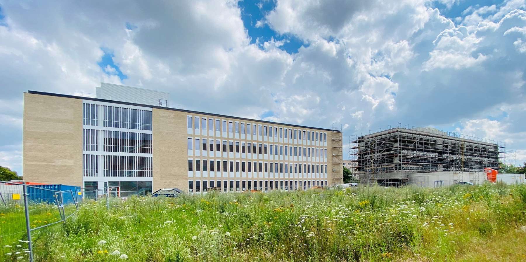 Neubau unter blauem Himmel mit weißen Wolken. Eine Wiese im Vordergrund. © 2020 Christian Hoffmann FM MV