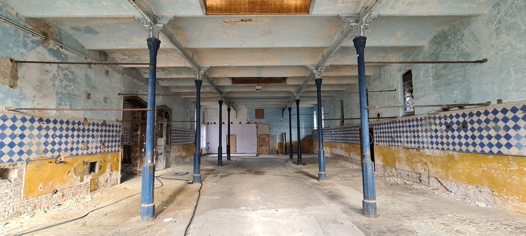 Blick in die Stallung des Südflügels mit historischem Stallfußboden und Fliesenspiegel der Wände © 2021 SBL Neubrandenburg