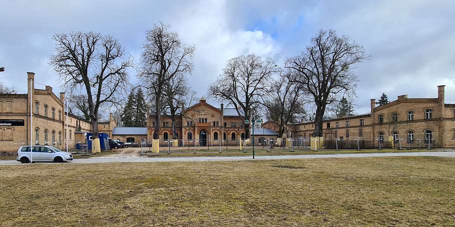Hofansicht des Marstalls mit Nordflügel (links), Mittelteil und dem Südflügel gesichert mit einem Bauzaun für die Arbeiten im 4. Bauabschnitt © 2021 SBL Neubrandenburg