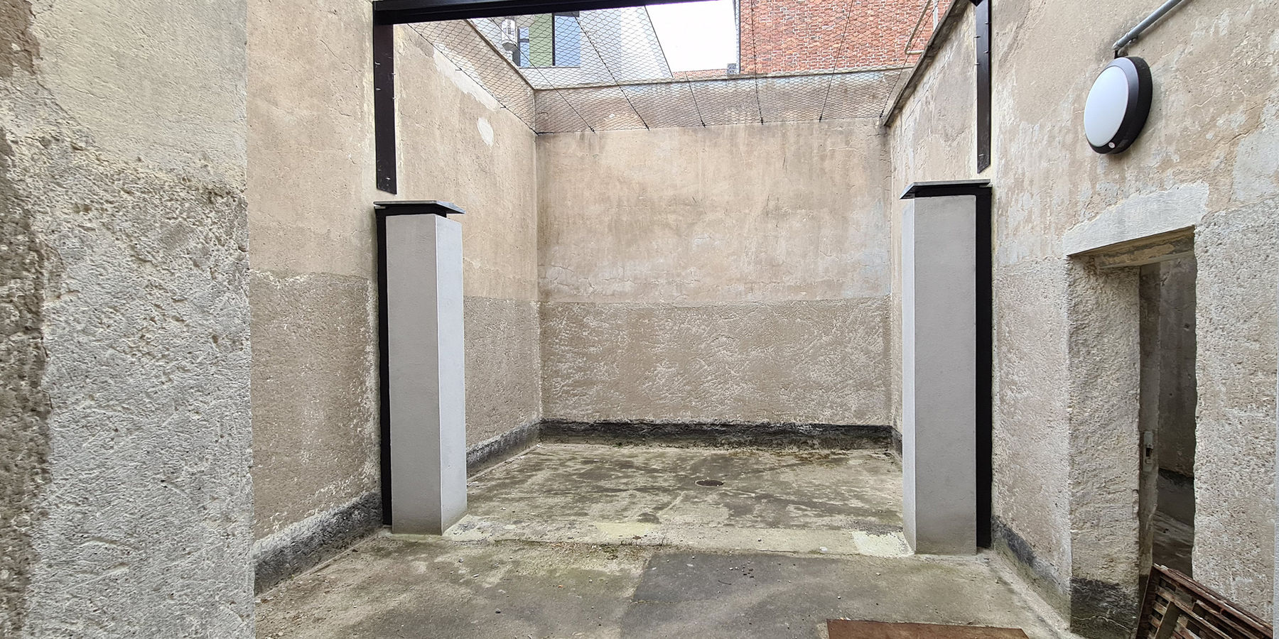 Der Hof für den Freigang wurde behutsam restauriert. Die Mauer und Werksteinabdeckungen am Freigang sind instandgesetzt. Die beiden Pfeiler deuten die nicht mehr vorhandene Trennwand an. © 2021 SBL Neubrandenburg