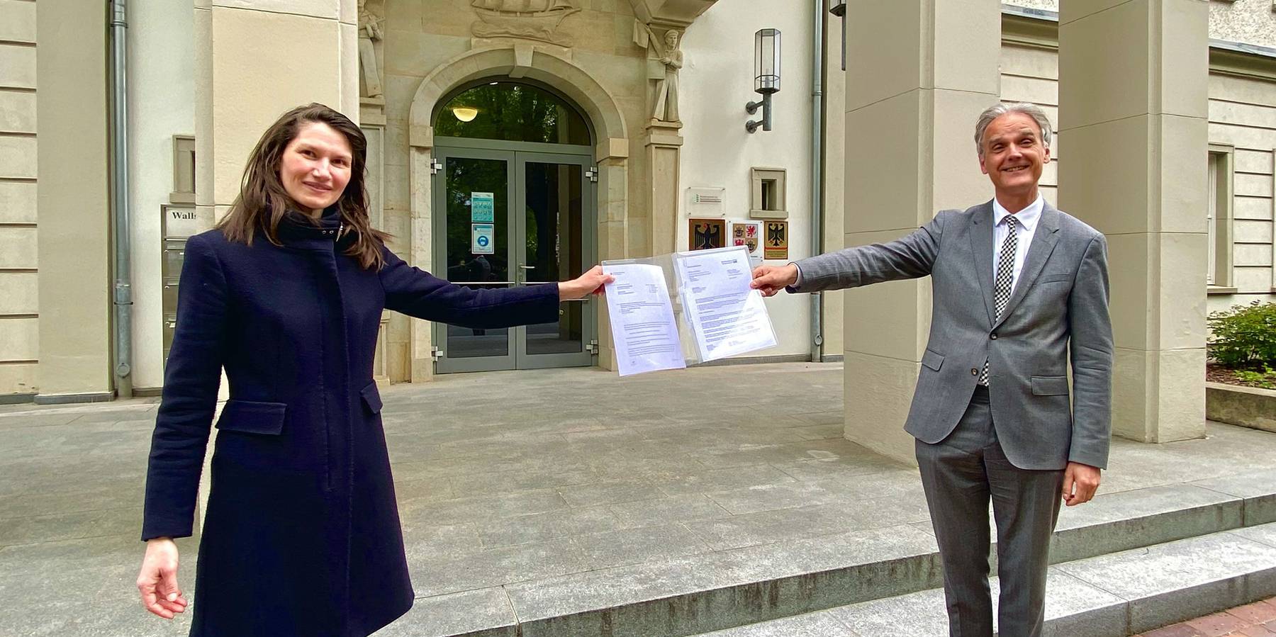 Auftrag erteilt - Uwe Jannsen (re.), Beauftragter für den Bundesbau im Finanzministerium M-V übergibt den Auftrag zur Erstellung eines sogenannten K1-Gutachtens an Carmen-Alina Botezatu (li.), die Leiterin des Staatlichen Bau- und Liegenschaftsamtes Rosto © 2021 Christian Hoffmann, FM M-V