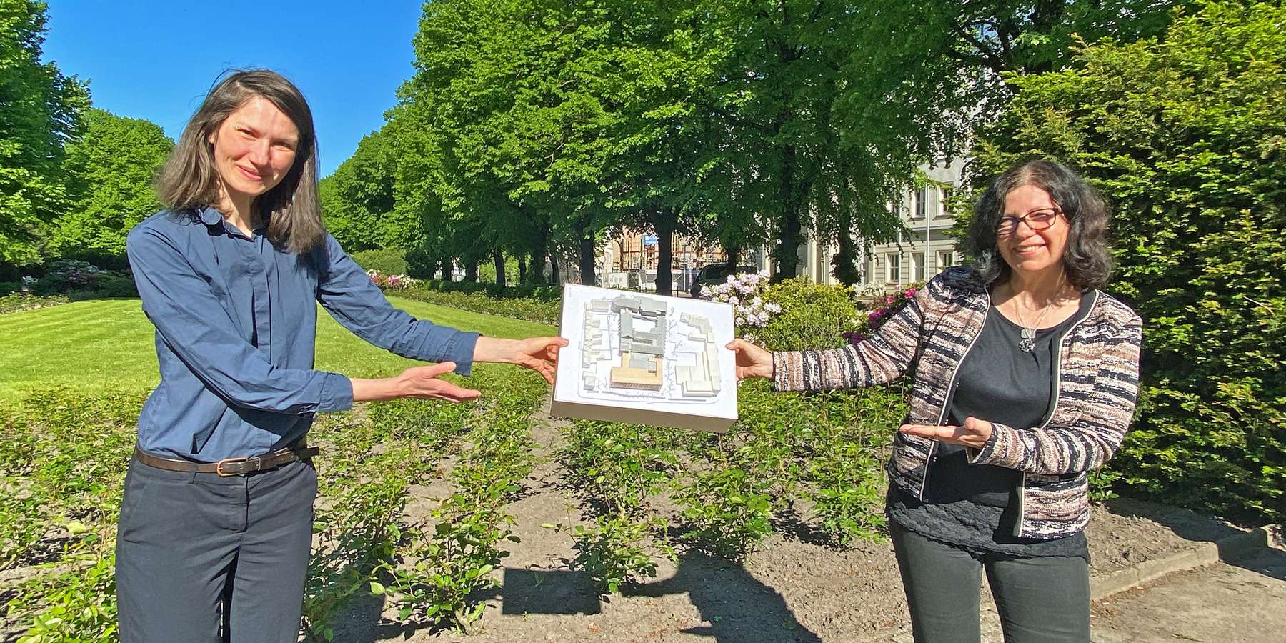 Strahlende Aussichten: Leiterin des SBL Rostock Carmen-Alina Botezatu und Projektmanagerin Heike Wehrle zeigen das Modell des innerstädtischen Quartiers, in dem die HMT um den Neubau erweitert wird. © 2021 Christian Hoffmann, FM M-V