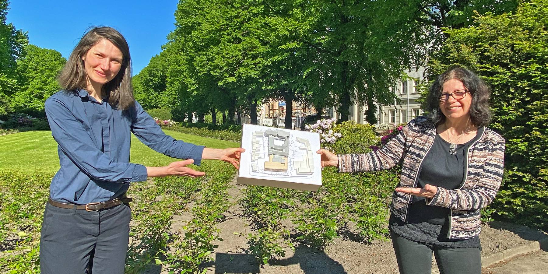 Strahlende Aussichten: Leiterin des SBL Rostock Carmen-Alina Botezatu und Projektmanagerin Heike Wehrle zeigen das Modell des innerstädtischen Quartiers, in dem die HMT um den Neubau erweitert wird. © 2021 Christian Hoffmann, FM M-V
