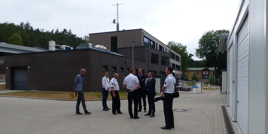 Besichtigung der rückwärtigen Außenanlagen mit Garagen, Carports und Stellplätzen - im Hintergrund der Polizeineubau mit eingeschossigem Gewahrsamstrakt © 2021 SBL Greifswald