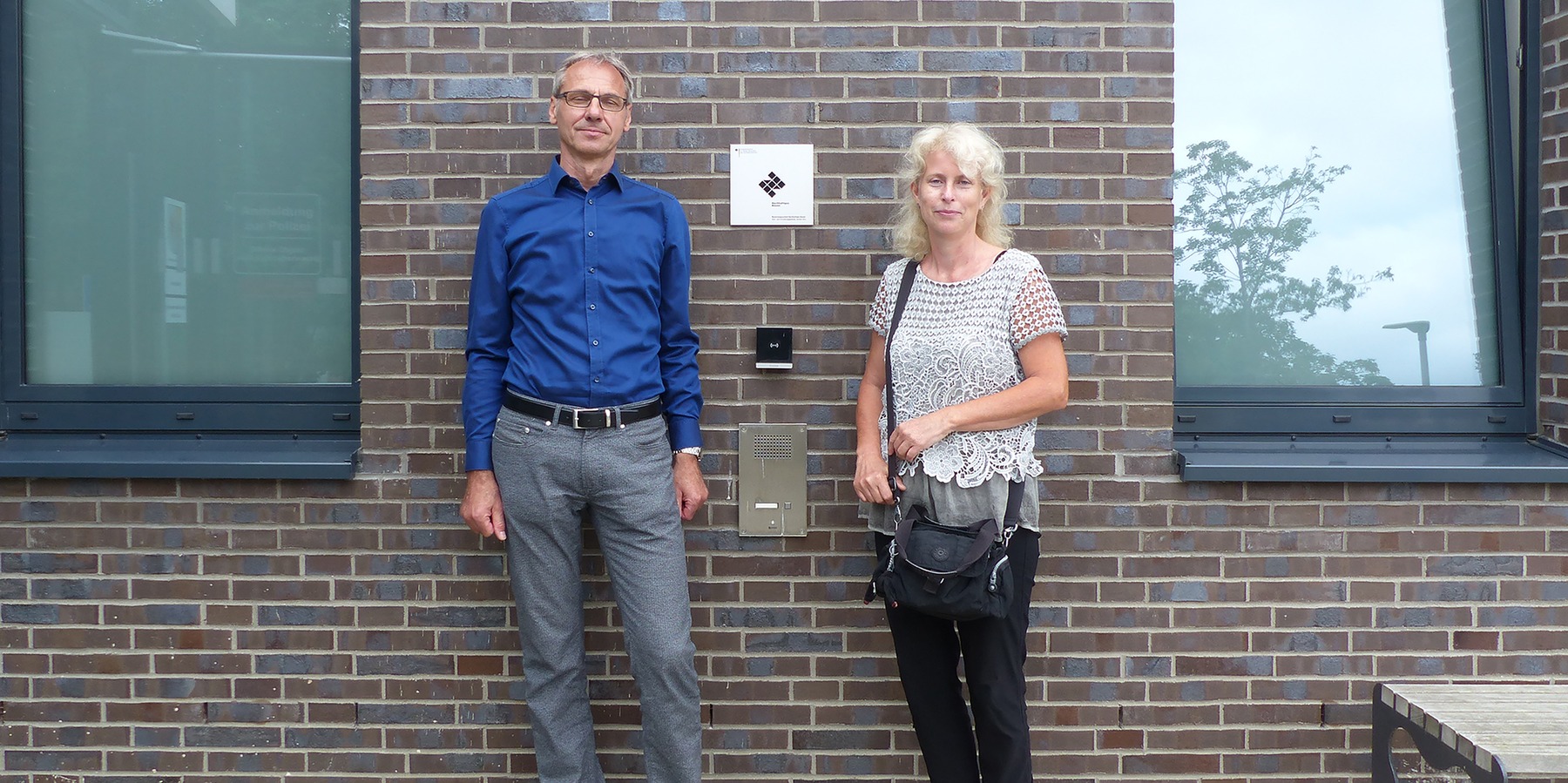 Amtsleiter Stephan Aufdermauer und die verantwortliche Projektleiterin Sina Stüwe vom SBL Greifswald vor der Eingangsfassade mit BNB-Silber-Plakette © 2021 SBL Greifswald