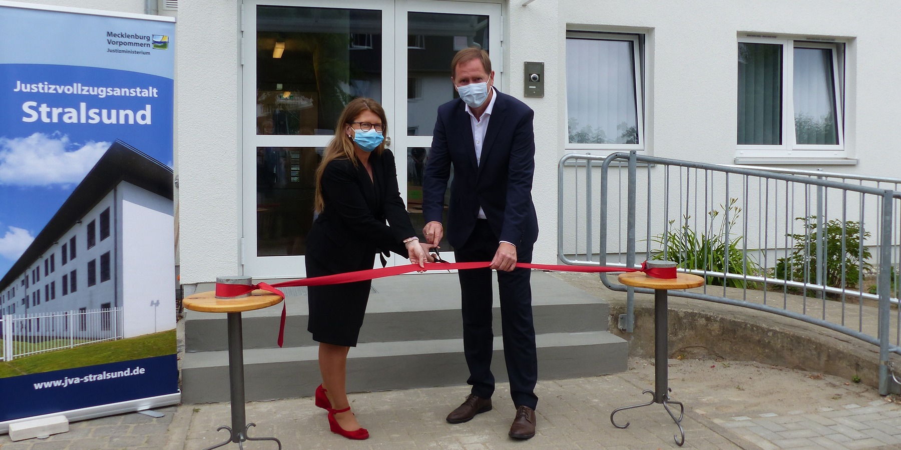 Justizministerin Katy Hoffmeister und Finanzstaatssekretär Heiko Miraß: Mit dem gemeinsamen Durchtrennen des roten Bandes ist die Feierliche Übergabe des Freigängerhauses an den Nutzer nun offiziell vollzogen - Das Haus steht zur Nutzung bereit. © 2021 SBL Greifswald