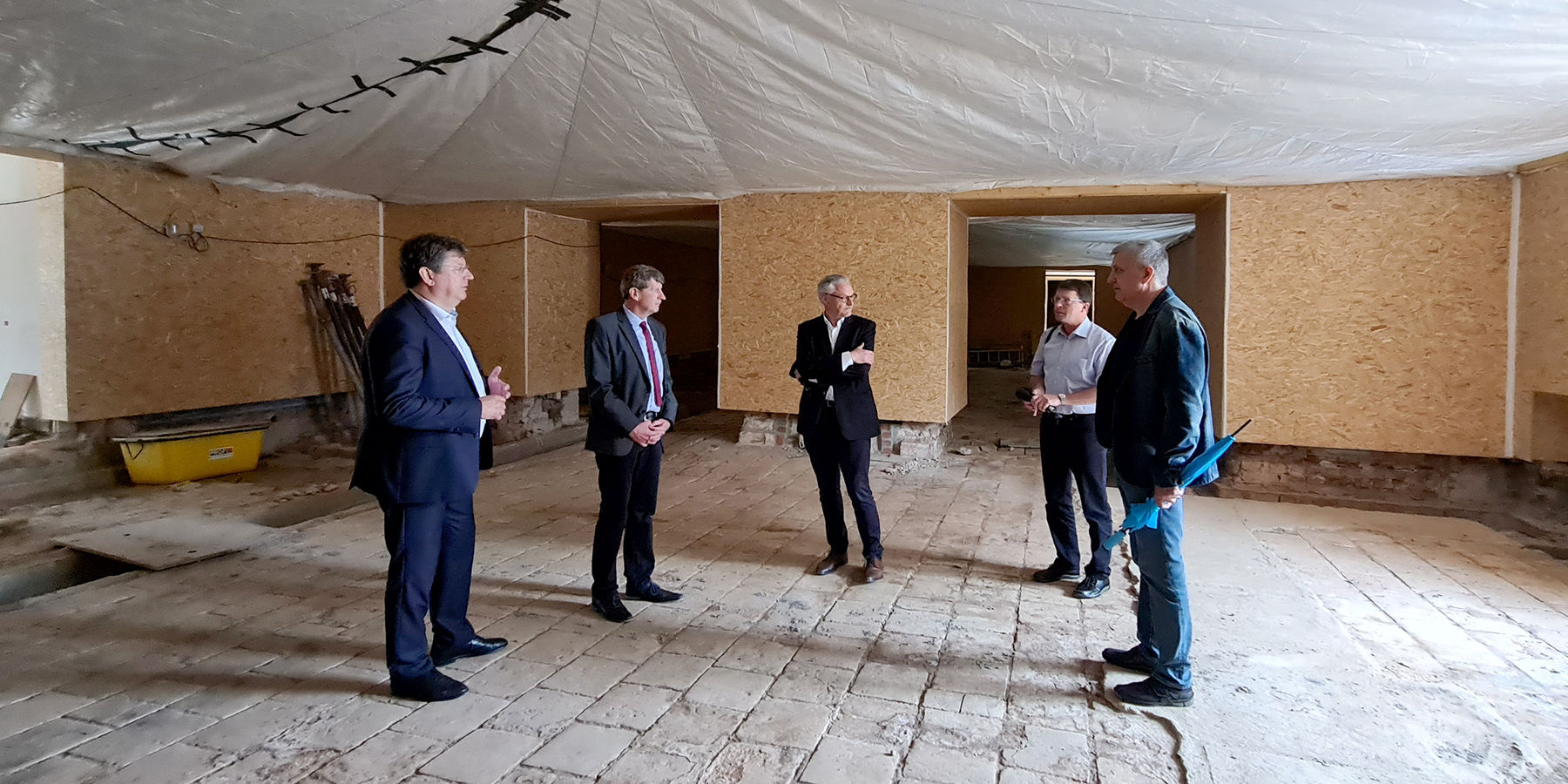 Im Blauen Saal im Mittelrisalit auf dem während der Bauarbeiten wieder gefundenen originalen Fußboden aus Terrakotta aus der Zeit um 1844 im Gespräch: v. l. n. r. Finanzminister Reinhard Meyer; Eckhard Hinz, stellvertretender Leiter des SBL Neubrandenburg © 2021 SBL Neubrandenburg