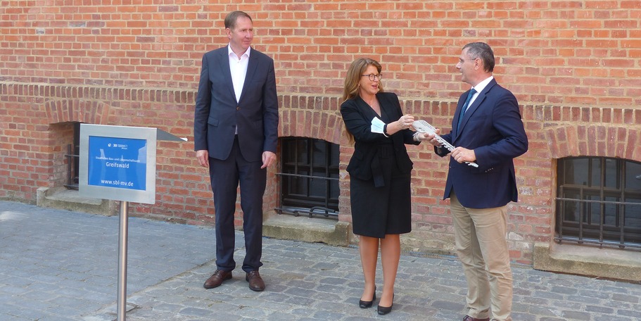 Dr. Sascha Ott, Direktor des Amtsgerichtes Stralsund und der Zweigstelle Bergen, nimmt den symbolischen Schlüssel aus den Händen der Justizministerin Katy Hoffmeister entgegen © 2021 SBL Greifswald