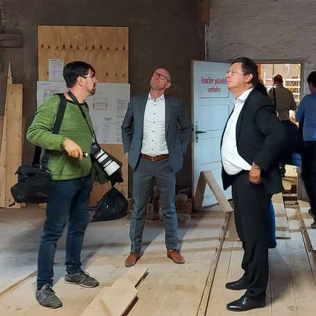 Bauamtsleiter Robert Klaus (Mitte) und Finanzminister Reinhard Meyer (rechts) im Gespräch mit Bauforscher Dr. Tilo Schöfbeck (links). © 2021 SBL Schwerin