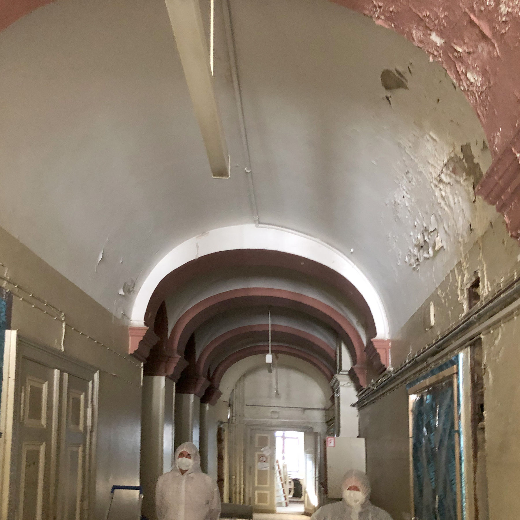 Beim Rundgang mit Schutzanzügen durch den Flur mit Kreuzgradgewölbe © 2021 Staatliches Bau- und Liegenschaftsamt Neubrandenburg