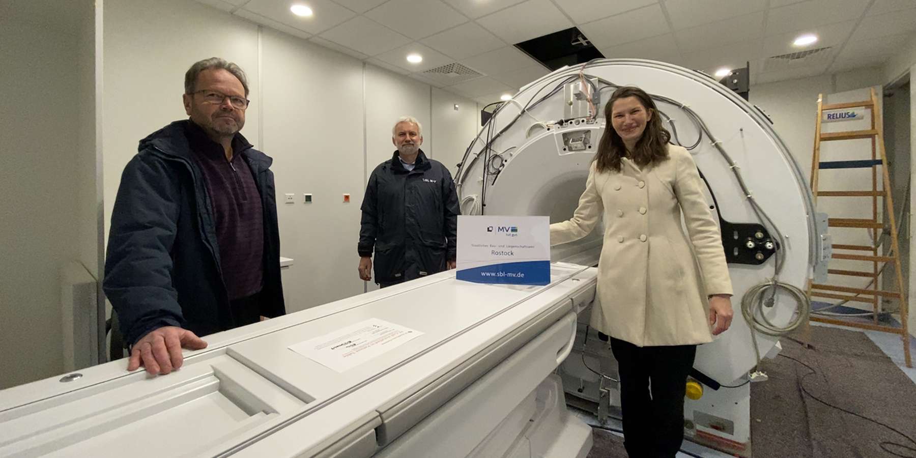 Der  Kleine  ist geschafft! Der erste MRT mit einem Gewicht von 7,5 Tonnen steht seit dieser Woche an seinem Bestimmungsort im Neubau des ZMF. Olaf Daleske, Hans-Joachim Jacobi und Carmen-Alina Botezatu vom für den Bau verantwortlichen SBL Rostock. © 2021 Christian Hoffmann, FM M-V