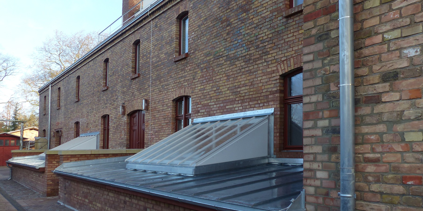Blick von Südosten auf den rückwärtigen Sozialtrakt mit seiner Fassade aus Backsteinen © 2021 SBL Greifswald