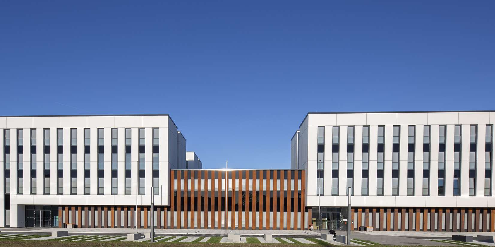 Kontrastprogramm. Der mittlere Teil des massiven Neubaus grenzt sich durch Material und Farbe von den beiden Flügeln ab. © 2022 Christian Hoffmann, FM M-V