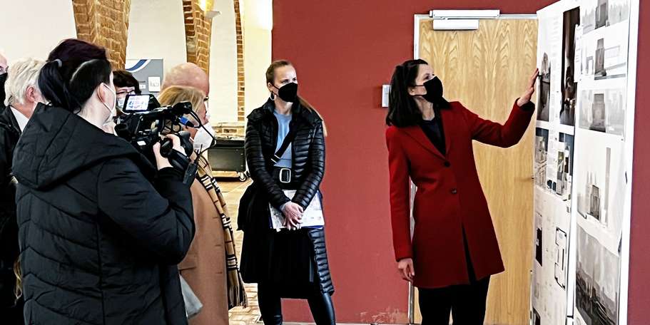 Carmen-Alina Botezatu, Leiterin des SBL Rostock, und Manuela Schwanitz, Projektleiterin im SBL Rostock, stellen hier bei der Eröffnung der Ausstellung den Siegerentwurf vor. © 2022 Christian Hoffmann, FM M-V