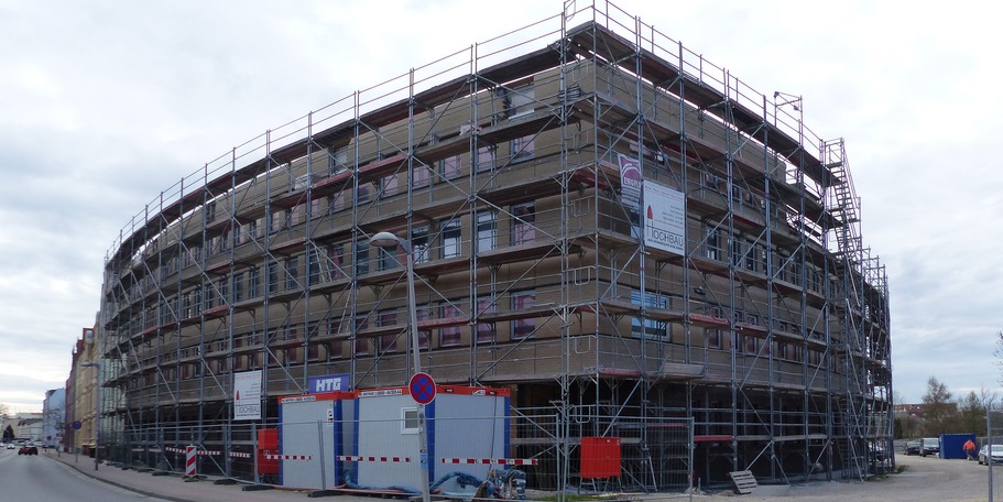 Der eingerüstete Neubau von der Barther Straße aus, an der Ecke der zukünftige Haupteingang für Besucher - die gebogene Klinkerfassade ist kurz vor ihrer Fertigstellung © 2022 Staatliches Bau- und Liegenschaftsamt Greifswald