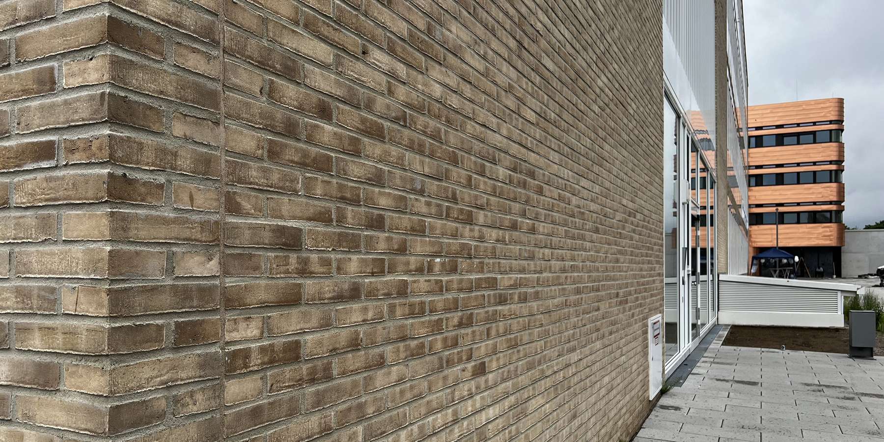 Backsteinklinker der Fassade. Im Hintergrund ist ein Teil der Fassade des Neubaus E-Technikum zu sehen. © 2022 Christian Hoffmann (SBL-MV, Finanzministerium M-V)