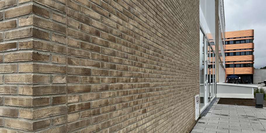 Backsteinklinker der Fassade. Im Hintergrund ist ein Teil der Fassade des Neubaus E-Technikum zu sehen. © 2022 Christian Hoffmann (SBL-MV, Finanzministerium M-V)
