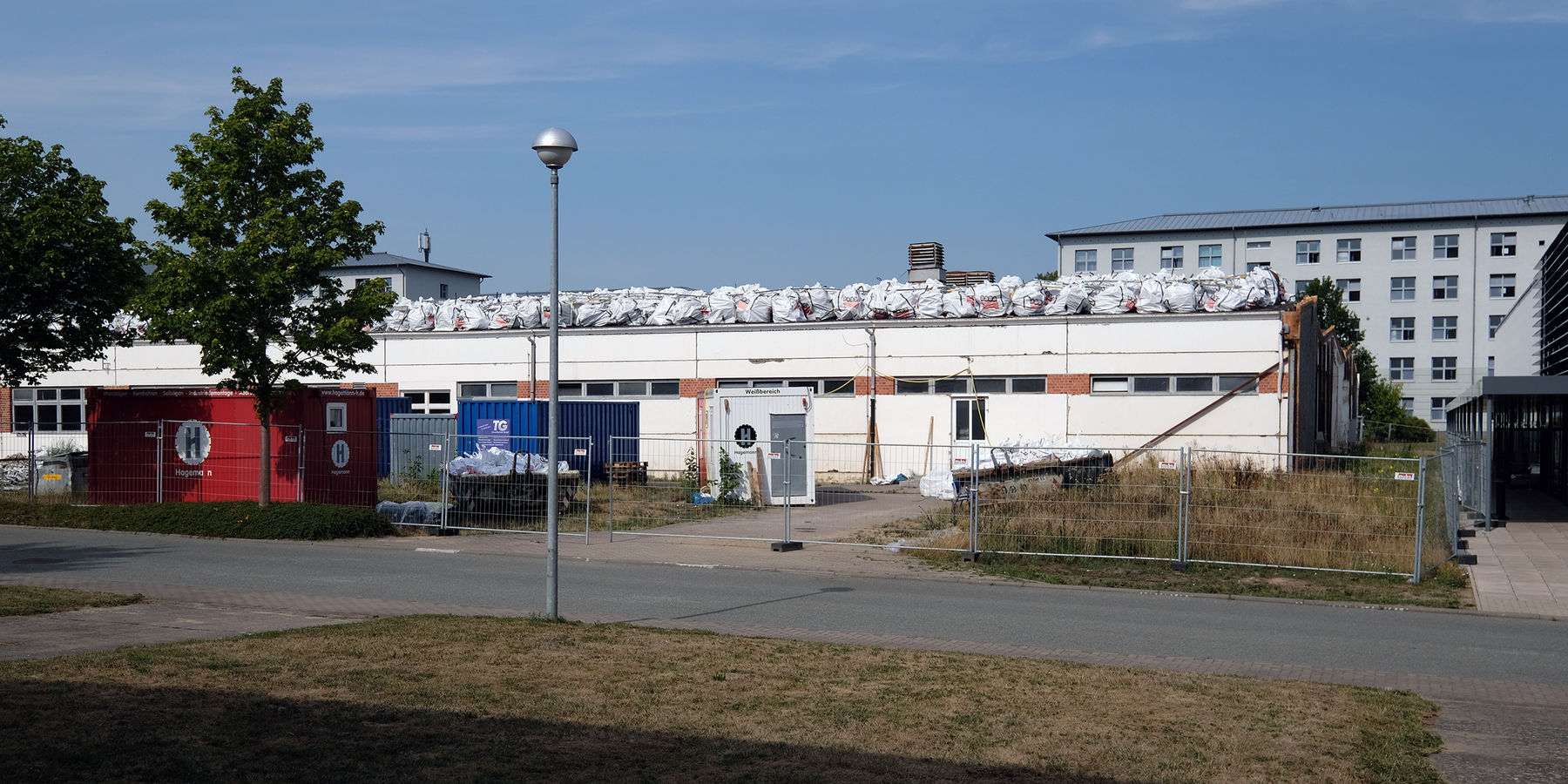 Seitenansicht des alten Wirtschaftsgebäudes mit Schutt gefüllten Säcken © 2022 SBL Schwerin