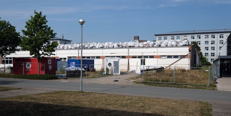 Seitenansicht des alten Wirtschaftsgebäudes mit Schutt gefüllten Säcken © 2022 SBL Schwerin