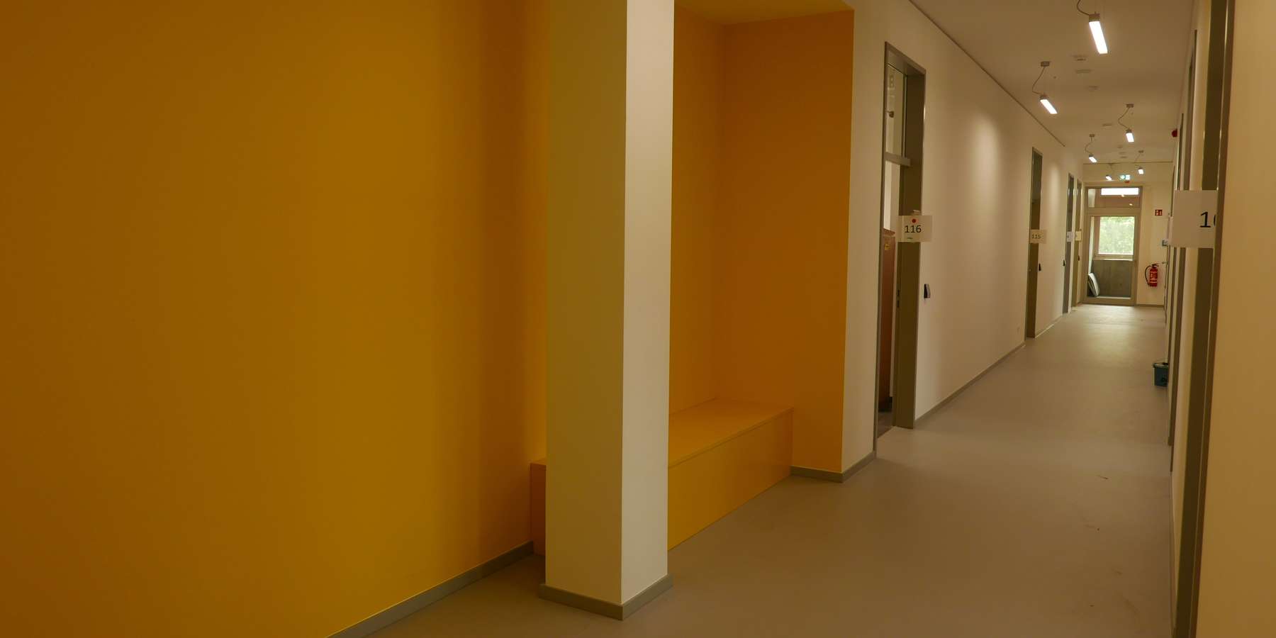 Die Kommunikationszonen in den Verkehrswegen wurden in den kräftigen Farben des jeweiligen Geschosses ausgeführt- hier ein langer Flur mit gelben Wänden © J.Rott