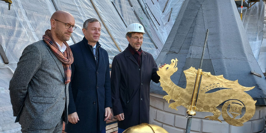 Vor dem Transport in die Höhe: Robert Klaus, Heiko Geue, Arne Schult hinter der vergoldeten Turmkapsel und dem Drachen © 2022 SBL Schwerin