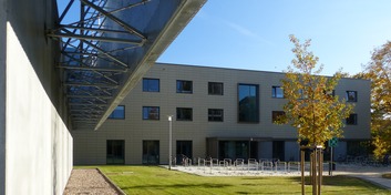 Rechenzentrum mit Rechnergebäude links und Seminar- und Verwaltungsgebäude rechts - Schutz vor Lärmbelästigung durch die Rückkühler auf dem Dach des Rechnergebäudes wird durch eine umlaufende vorgesetzte Lärmschutzfassade gewährleistet © 2021 SBL Greifswald