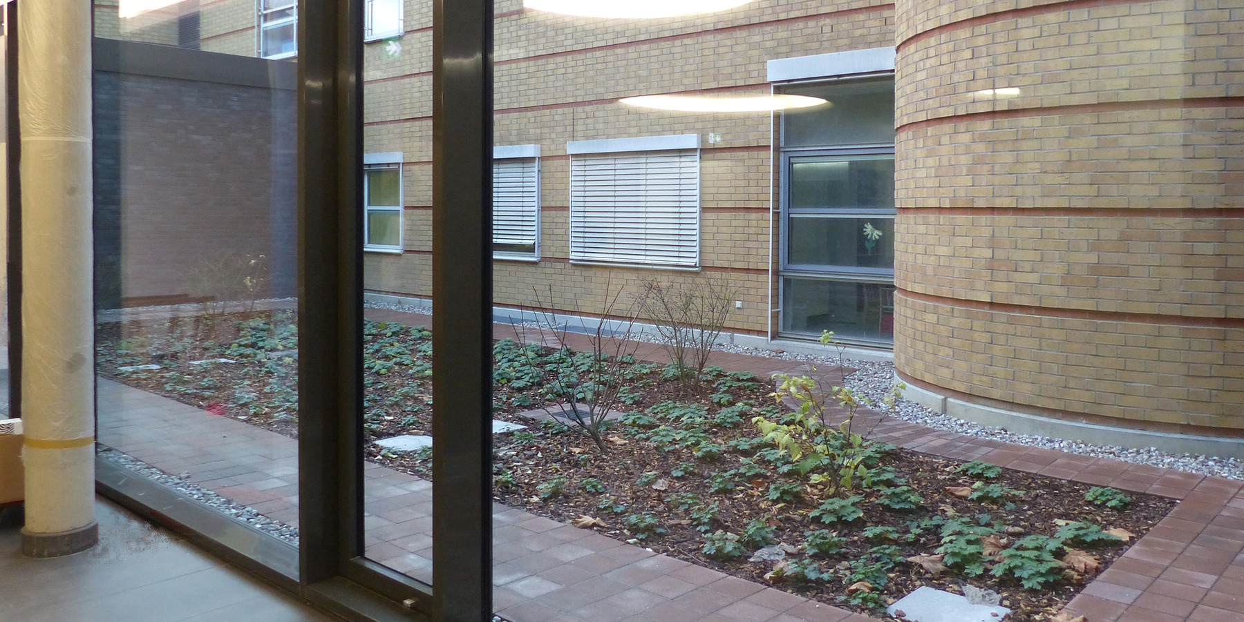 Flur im Erdgeschoss mit Blick in den begrünten Innenhof zwischen Neubau und Bestand © 2019 Betrieb für Bau und Liegenschaften Mecklenburg-Vorpommern