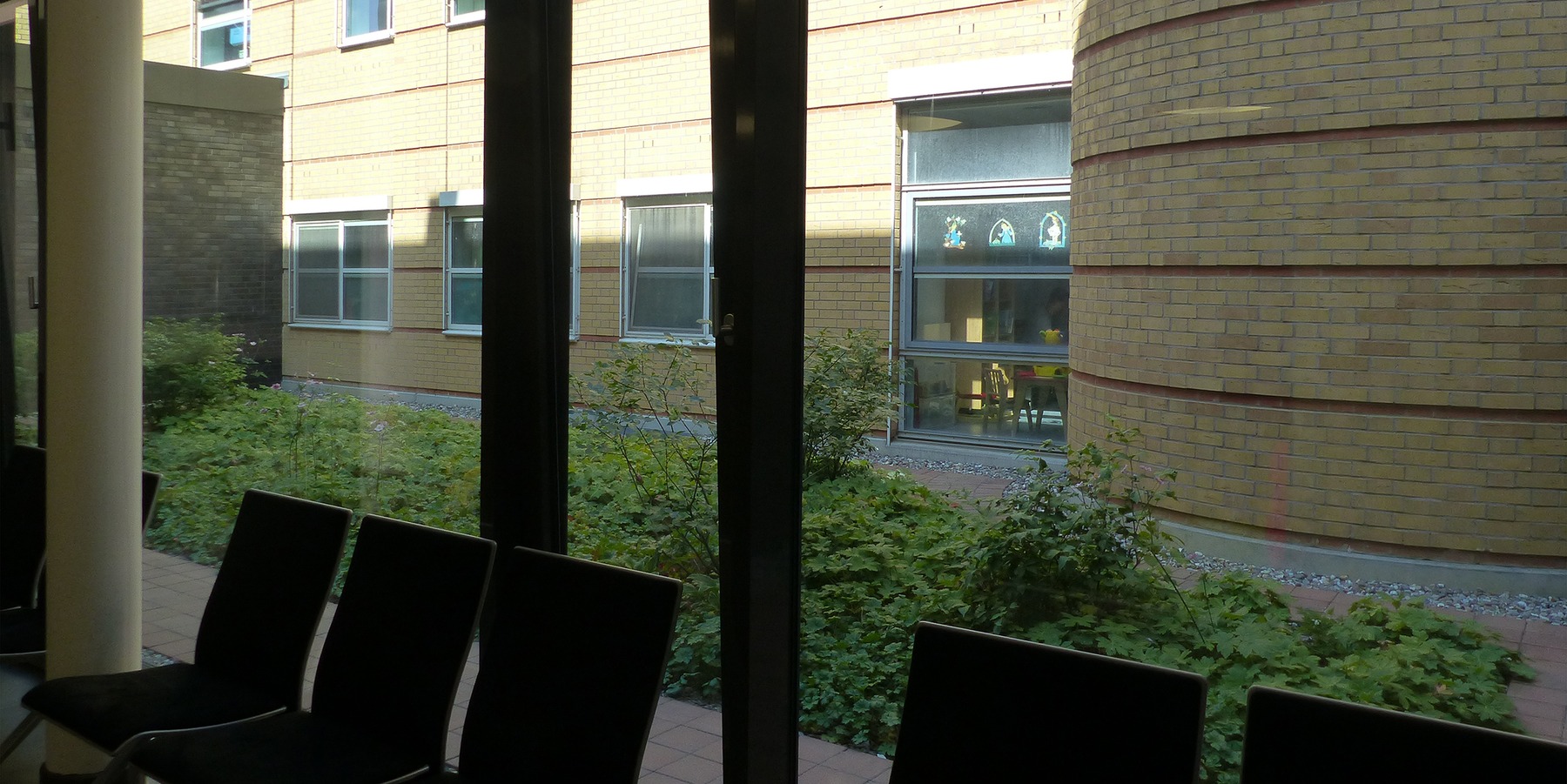 Flur mit Wartezone im Erdgeschoss mit Blick in den begrünten Innenhof zwischen Bestand und Neubau © 2019 Betrieb für Bau und Liegenschaften Mecklenburg-Vorpommern