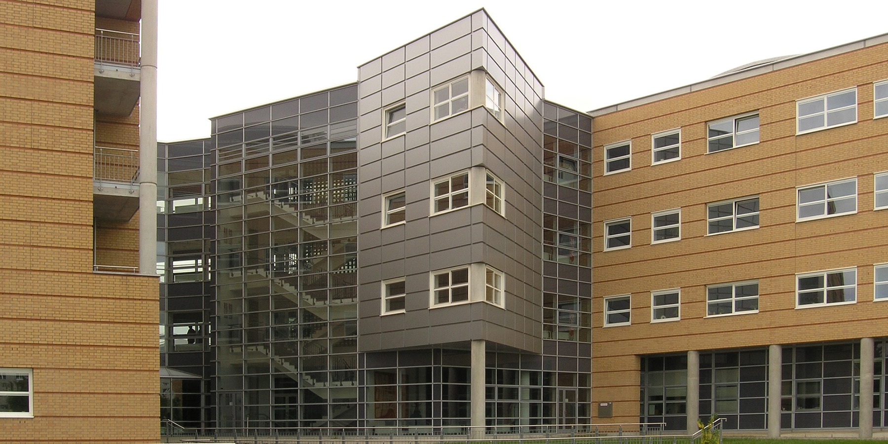 Glas, Aluminium und Stahl sind als komplettierende Materialien zur Markierung besonderer Bereiche und Gebäudegrenzen zu finden - hier zwischen den Bettentürmen des 1. Bauabschnittes © 2005 Betrieb für Bau und Liegenschaften Mecklenburg-Vorpommern