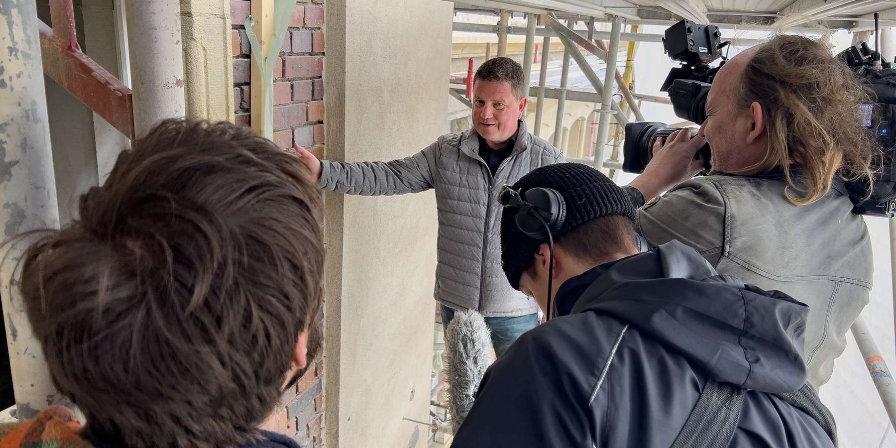 Projektleiter und Drehteam auf dem Baugerüst © 2023 Christian Hoffmann (sbl-mv / Finanzministerium MV)