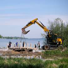 Ein Bagger hebt den Brückenüberbau auf die Widerlager. © 2023 SBL Schwerin