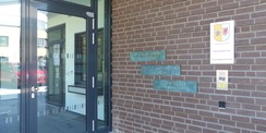 Überdachte Eingangszone mit Dienststellenbeschilderung und Schrifttafeln des Kunst am Bau-Objektes © 2023 SBL Greifswald