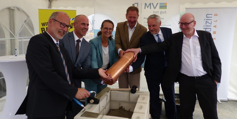 Der erste Akt ist geschafft: das Mörtelbett ist fertig, die Kartusche kann eingelegt und vermauert werden, v.l.n.r.: Prof. Dr. med. MPH Wolfgang Hoffmann, Prof. Dr. med. Uwe Reuter, Bettina Martin, Heiko Miraß, Stefan Wenzl, Dr. Tilmann Schweisfurth © 2023 SBL Greifswald