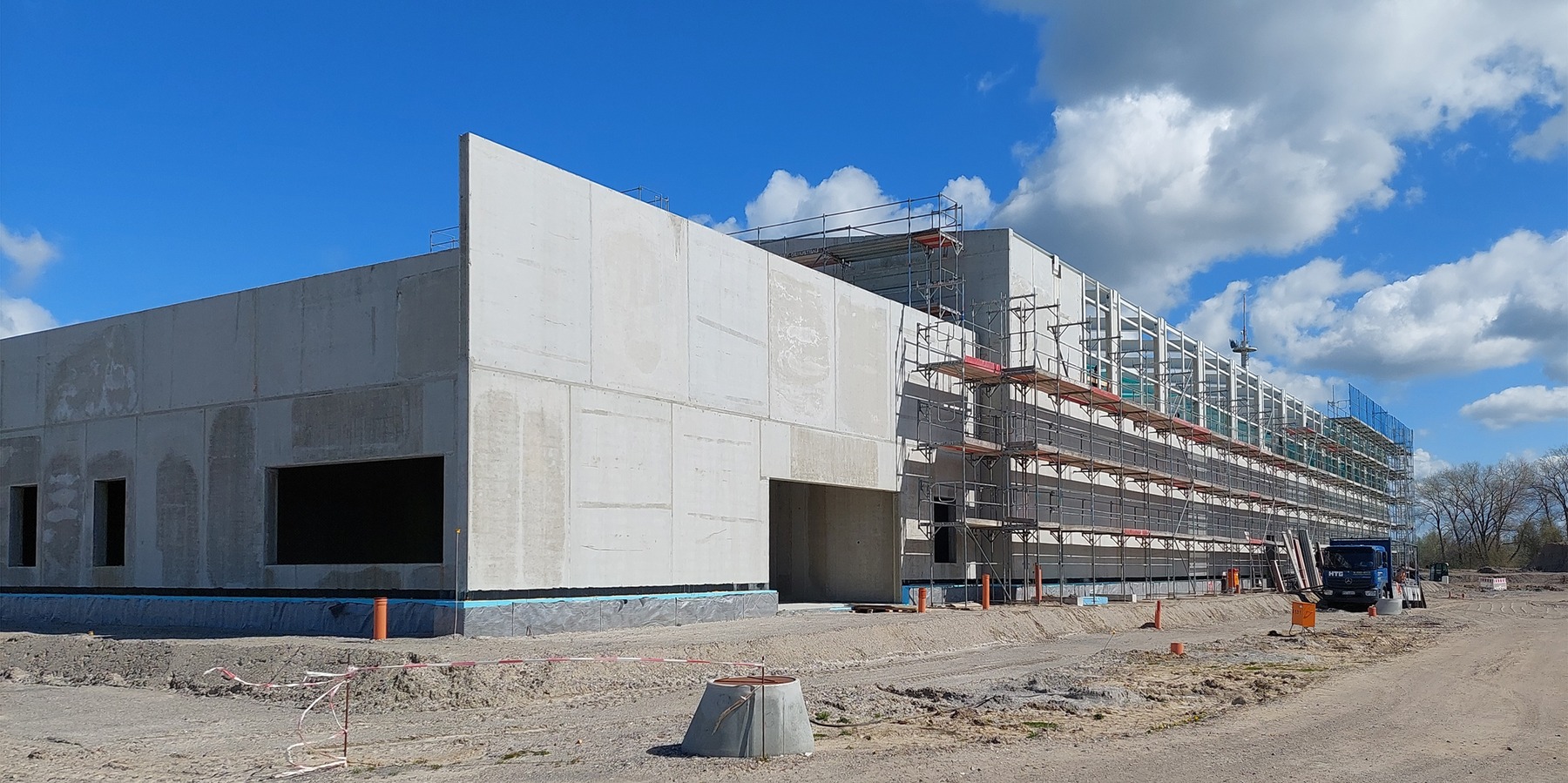 Blick auf den Rohbau der 2-geschossigen Halle mit 1-geschossigem Anbau an der Giebelseite © 2023 Lammel, Lerch   Partner mbH, Berlin