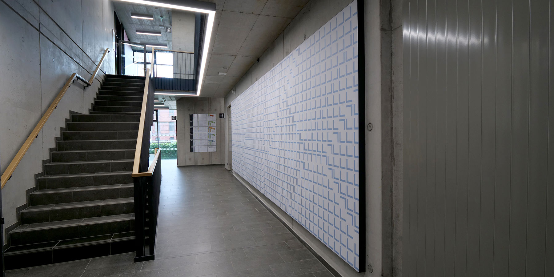 Blick in das Treppenhaus im Erdgeschoss mit der künstlerischen Gestaltung der Absorber nach Entwürfen von Susanne Gabler © 2023 SBL Neubrandenburg