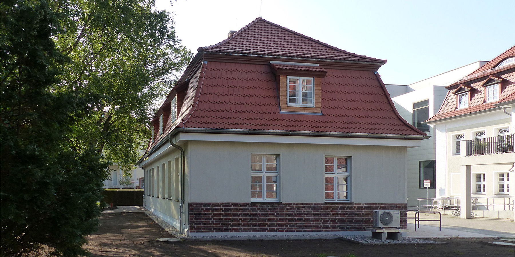 Giebelansicht - Blick von Osten (am Bildrand rechts das bereits sanierte historische Klinikgebäude aus der Erbauungszeit - ehemaliges Säuglingsheim von 1915) © 2023 SBL Greifswald