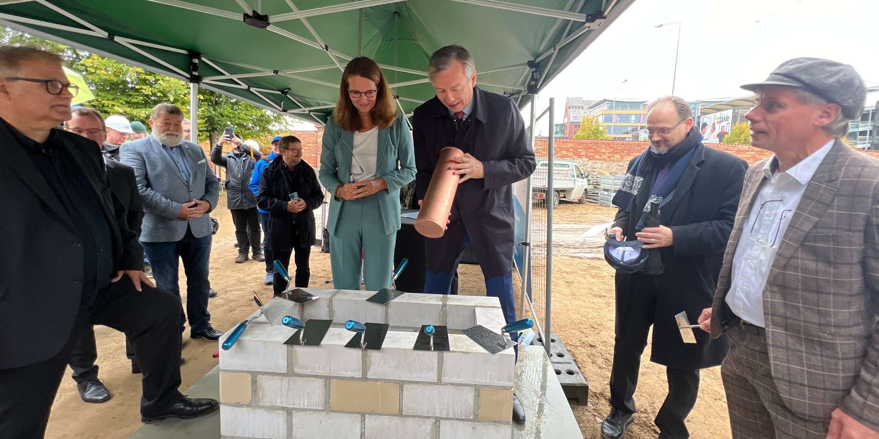 Die Zeitkapsel wird unter Beobachtung der Gäste, durch Wissenschaftsministerin Bettina Martin und Finanzminister Dr. Heiko Geue gelegt. © 2023 Christian Hoffmann (Finanzministerium M-V / sbl-mv)