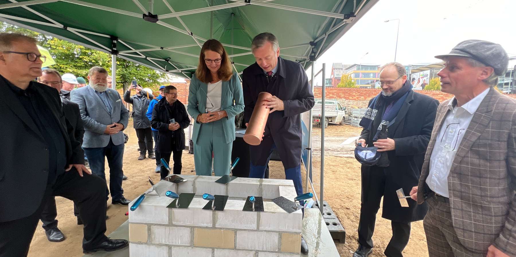 Die Zeitkapsel wird unter Beobachtung der Gäste, durch Wissenschaftsministerin Bettina Martin und Finanzminister Dr. Heiko Geue gelegt. © 2023 Christian Hoffmann (Finanzministerium M-V / sbl-mv)